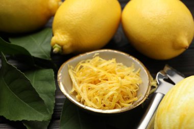 Limon lezzeti, taze meyve ve zester aleti ahşap masada, yakın plan.