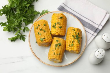 Beyaz mermer masada maydanozlu haşlanmış mısır koçanı parçaları.