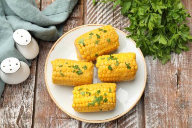 Tahta masada maydanozlu haşlanmış mısır koçanı parçaları.