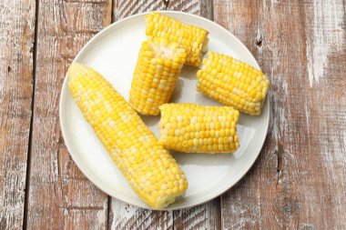 Pieces of boiled corncobs on wooden table, top view