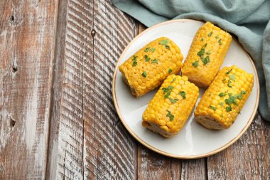 Ahşap masada maydanozlu haşlanmış mısır koçanı parçaları. Metin için boşluk