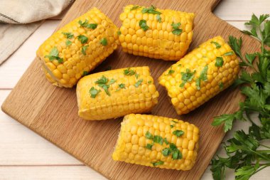 Tahta masada maydanozlu haşlanmış mısır koçanı parçaları.