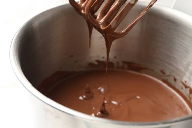 Çikolata hamuru mikserden kaseye damlıyor, yakın plan.