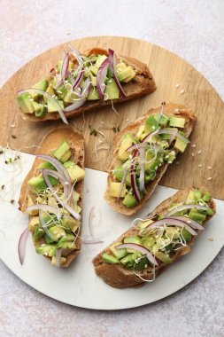 Avokado, soğan ve mikro yeşillikli nefis bruschetalar açık dokulu masa, üst görünüm