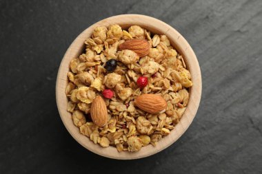 Kurutulmuş meyveli lezzetli granola ve siyah masada fındık.