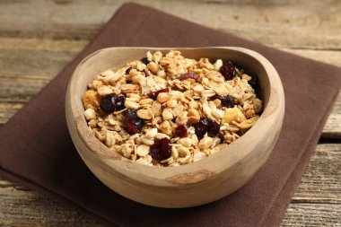 Tahta masada kurumuş meyveli lezzetli granola, yakın plan.