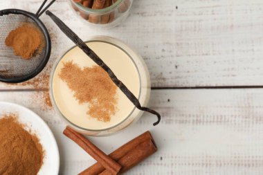 Lezzetli protein karışımı, beyaz ahşap masa üzerinde tarçın ve vanilya. Metin için boşluk