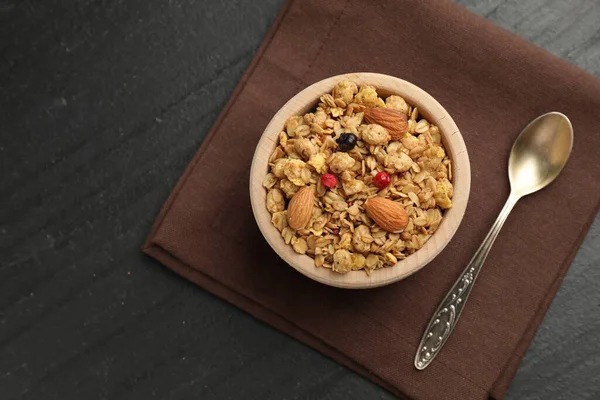 Lezzetli granola, kurutulmuş meyve ve fındıklar siyah masada, düz yerde. Metin için boşluk