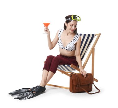 Dalış maskesi ve beyaz arka planda iskemlede kokteyli olan bir iş kadını.