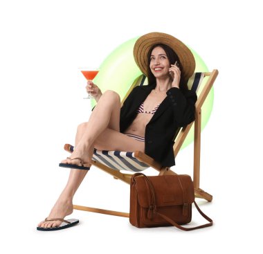 Kokteyl içen iş kadını güverte koltuğunda beyaz arka planda akıllı telefonla konuşuyor.