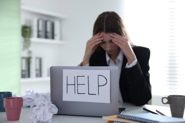 İşaretli kadın, masadaki dizüstü bilgisayarda yardım, seçici odaklanma