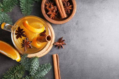 Lezzetli, portakallı, baharatlı ve köknar dallı beyaz şarap. Koyu dokulu masa, düz yatak. Metin için boşluk