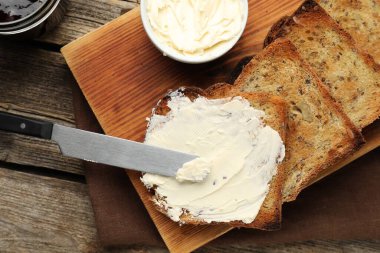 Tahta masada kızarmış ekmek, tereyağı ve reçel.