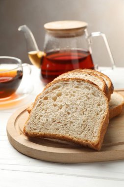 Beyaz ahşap masada çay eşliğinde ekmek dilimleri