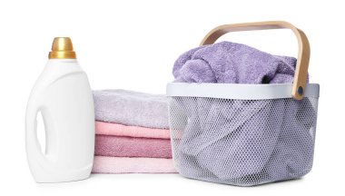 Çamaşır sepeti, yumuşak havlular ve beyaz üzerine izole edilmiş bir şişe deterjan.