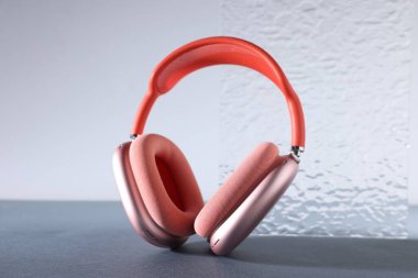 Gri masaya bir çift şık kulaklık, yakın plan.