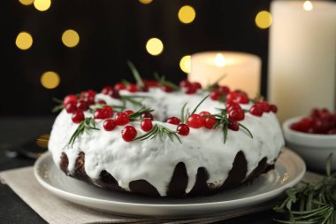 Bulanık ışıklara karşı kırmızı böğürtlenli ve biberiyeli lezzetli bir Noel pastası.