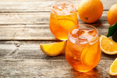 Bardaklar ferahlatıcı spritzer kokteyli ve portakallar ahşap masada, yakın plan. Metin için boşluk