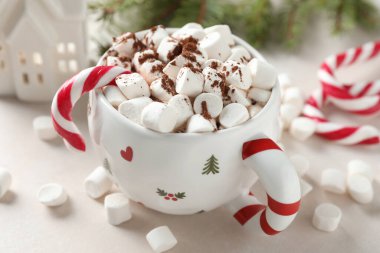 Marşmelovlu lezzetli kakao, baston şekerler ve ışık masasında Noel dekoru, yakın plan.