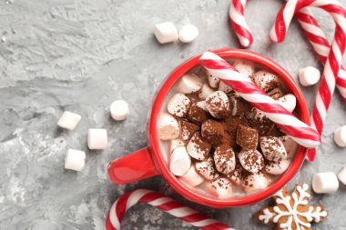 Noel atmosferi. Lezzetli kakao, şekerleme çubukları ve gri masada zencefilli kurabiye, düz yatak. Metin için boşluk