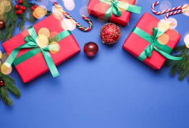 Paketlenmiş Noel hediyeleri ve mavi arka planda dekorasyon, düz yatış. Metin için boşluk