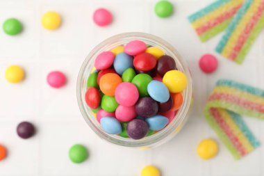 Beyaz döşeme üzerinde nefis renkli şekerler, düz yatıyordu.