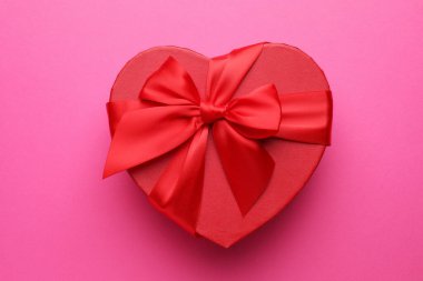 Pembe arka planda kalp şeklinde güzel bir hediye, üst manzara. Sevgililer Günü
