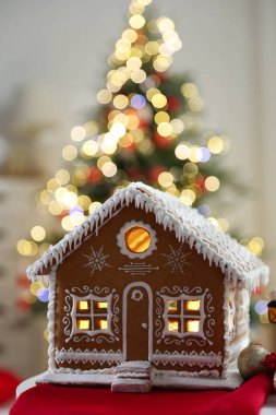 İçerideki bulanık ışıklara karşı masada nefis zencefilli kurabiye evi, yazı için yeri olan yakın plan. Noel atmosferi