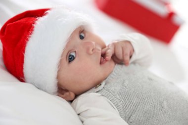 Yatakta Noel Baba şapkalı bebek, yakın plan. Noel sezonu