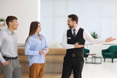 Oteldeki resepsiyonist misafirleri karşılıyor.