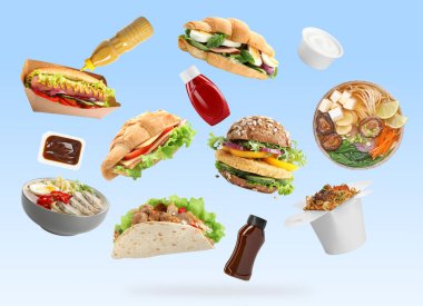 Açık mavi arka plana düşen farklı fast food ve soslar. Yemek servisi.