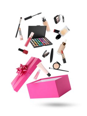 Dekoratif kozmetik ürünleri ve parfüm beyaz arka plana karşı hediye kutusuna düşüyor