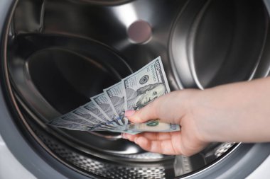 Çamaşır makinesine para koyan kadın, yakın plan.