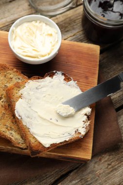 Tahta masada kızarmış ekmek, tereyağı ve reçel.