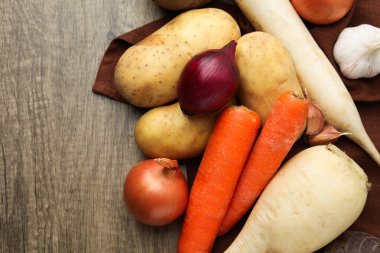 Tahta masada farklı çiğ sebzeler, düz uzanmış.