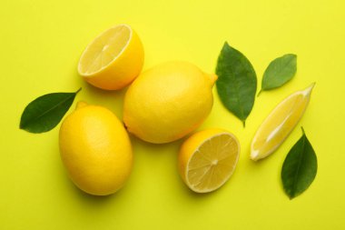 Taze olgun limonlar ve sarı arka planda yapraklar.