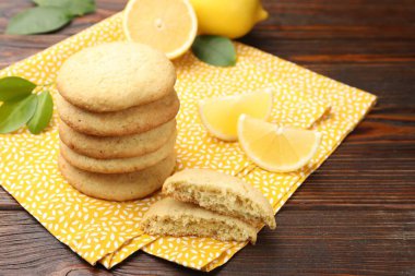 Lezzetli limonlu kurabiyeler ve ahşap masada meyve dilimleri, yakın plan.