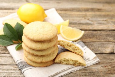 Lezzetli limonlu kurabiyeler ve ahşap masada meyve dilimleri, yakın plan.