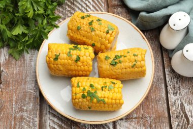 Tahta masada maydanozlu haşlanmış mısır koçanı parçaları.
