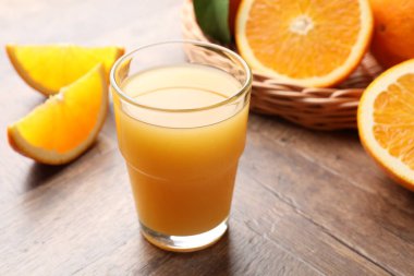 Taze portakal suyu ve ahşap masada meyveler, yakın plan.