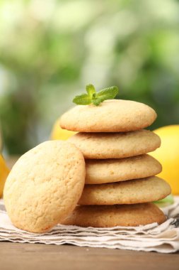 Lezzetli limonlu kurabiyeler, nane ve meyveler ahşap masada bulanık arka plan, yakın plan