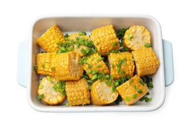 Haşlanmış mısır koçanı parçaları ve yeşil soğanlı fırın kabı beyaza izole edilmiş, üst manzara.