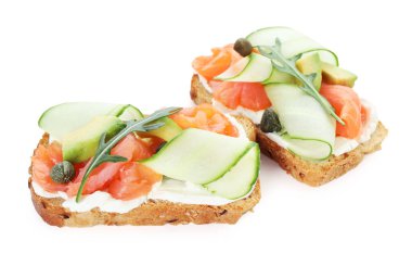 Somon, roka, avokado ve krem peynirli leziz bruschetalar beyaz üzerine izole edilmiş.