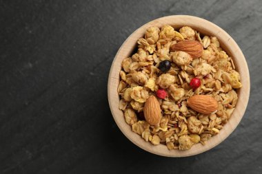 Lezzetli granola, kurutulmuş meyve ve fındıklar siyah masada, üst manzara. Metin için boşluk