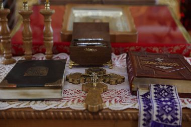 Mykolaiv, Ukrayna - 1 Kasım 2025: Haç, Kutsal İncil ve diğer dini semboller kilisedeki ahşap masada, yakın plan