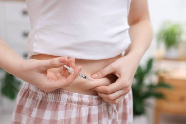 Tüp bebek için. Kadın karnına iğne yapıyor, kapalı alanda, yakın çekim.