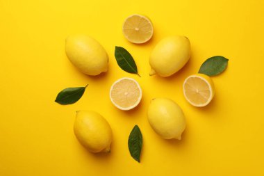 Taze olgun limonlar ve sarı arka planda yapraklar.