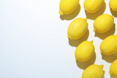 Beyaz arka planda taze olgun limonlar, düz uzanmış. Metin için boşluk