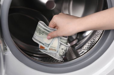 Çamaşır makinesine para koyan kadın, yakın plan.