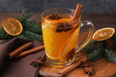 Cam bardakta baharatlı sıcak şarap, portakal dilimleri ve köknar dalları, yakın plan.